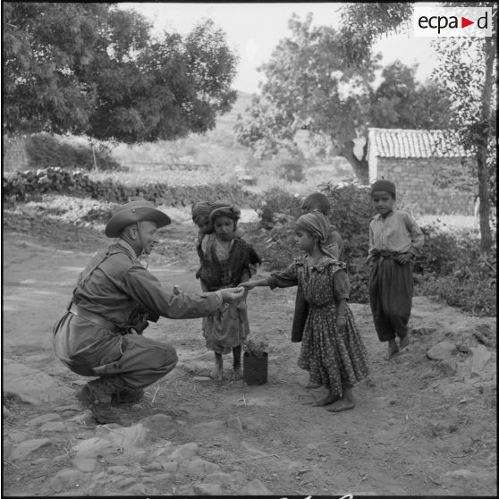 Distribution de bonbon aux enfants de Tala'n Taghrast par l'officier SAS (Section administrative spécialisée) de Tigzirt.