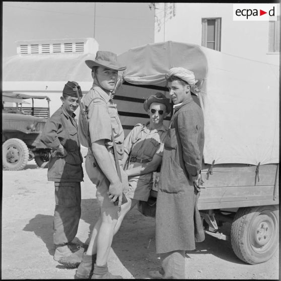 Soldats du 22e RI (régiment d'infanterie) discutant avec un marchand ambulant de légumes algérien à Paul Robert (Taougrite).