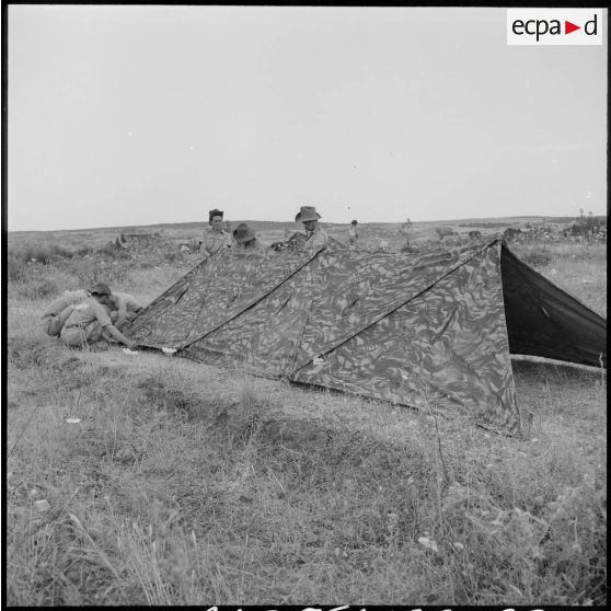 Montage de tente dans le bivouac de la 3e compagnie du 22e RI (régiment d'infanterie) dans la région d'Alger.