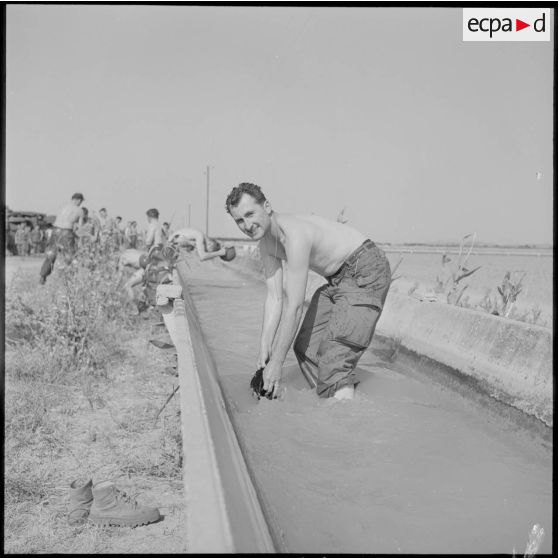 Portrait d'un soldat du 22e RI (régiment d'infanterie) lavant son linge dans un canal sur la route d'Orléansville.