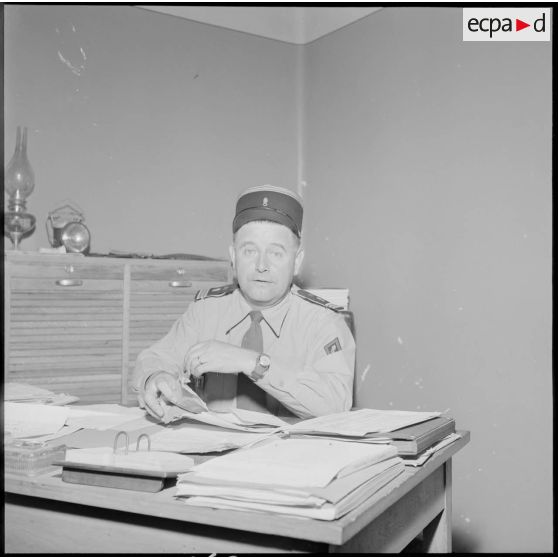 Portrait d'un capitaine commandant la CCS (compagnie de commandement et de services) du 3e REI (régiment étranger d'infanterie) dans son bureau à Arris.