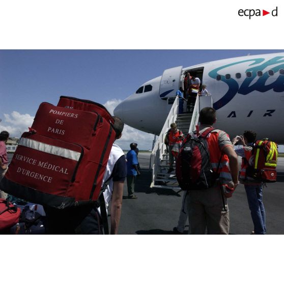 Personnels de la BSPP (Brigade des sapeurs-pompiers de Paris), du SAMU mondial et de la Croix-Rouge au pied de l'avion, avant l'embarquement des ressortissants évacués à l'aéroport international d'Abidjan.