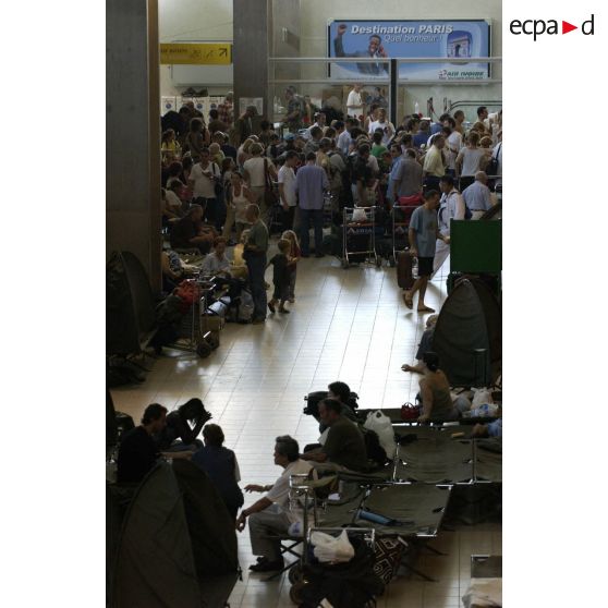 Les ressortissants français, évacués vers l'aéroport international d'Abidjan, attendent leur départ en compagnie d'autres ressortissants européens, dans la salle de l'aérogare où des lits Picot ont été installés.