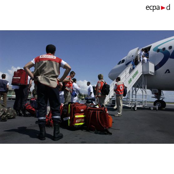 Personnels de la BSPP (Brigade des sapeurs-pompiers de Paris), du SAMU mondial et de la Croix-Rouge au pied de l'avion, avant l'embarquement des ressortissants évacués à l'aéroport international d'Abidjan.