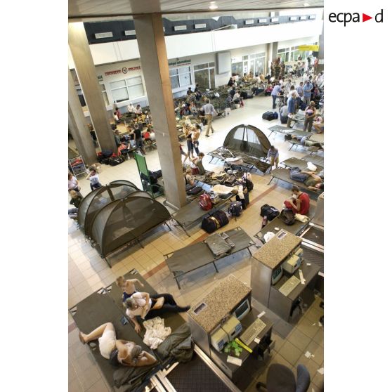 Les ressortissants français, évacués vers l'aéroport international d'Abidjan, attendent leur départ en compagnie d'autres ressortissants européens, dans la salle de l'aérogare où des lits Picot ont été installés.