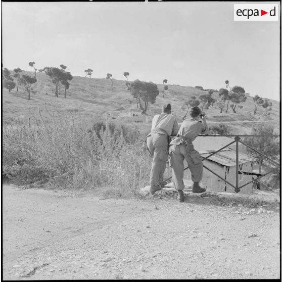 Du pont de la frontière situé au-dessus du poste douanier tunisien, le capitaine commandant la 4e compagnie du 153e régiment d'infanterie mécanisée (153e RIM), accompagné d'un sous-lieutenant, observe le territoire.