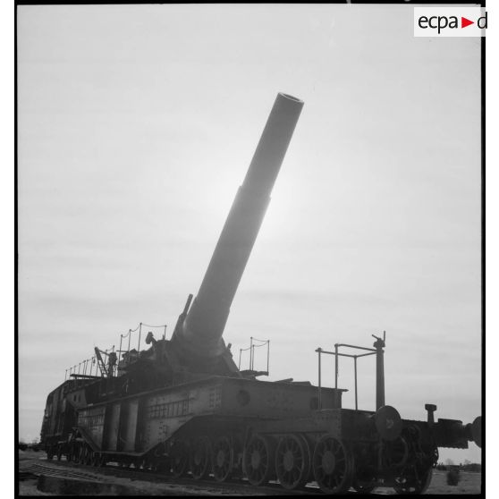 L'obusier de 400 mm de l'ALVF (artillerie lourde sur voie ferrée), baptisé maréchal-des-logis Lebeau, sur son affût-truck à berceau est photographié en plan général en contre-jour.