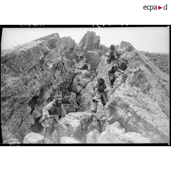 Des cavaliers druzes progressent à pied dans des rochers, ils tiennent en main leur mousqueton modèle 1892.