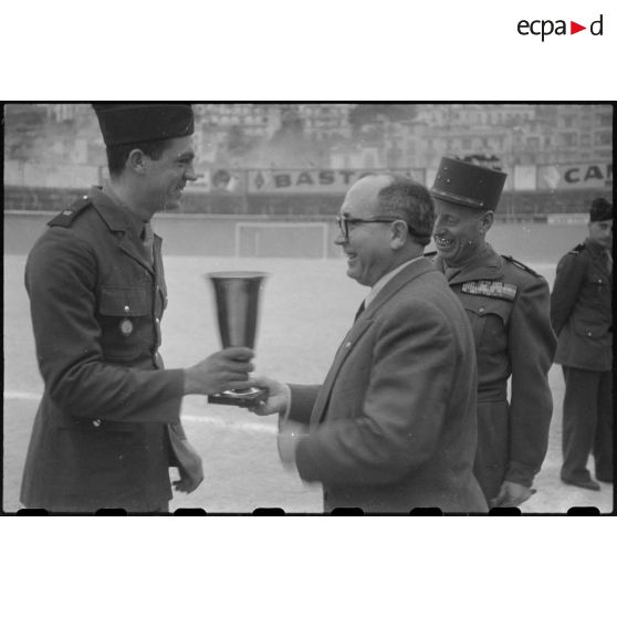 Remise de coupe à un militaire par une autorité civile lors d'un championnat militaire au stade municipal d'Alger.