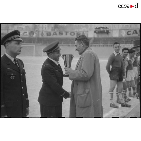 Remise de coupe à un militaire par une autorité civile au stade d'Alger lors d'un championnat militaire.