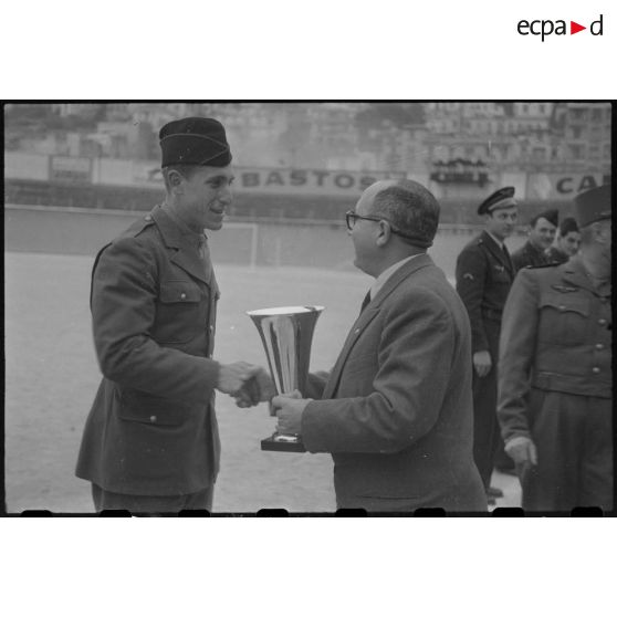 Remise de coupe par une autorité civile à un militaire lors de la finale d'un championnat militaire à Alger.