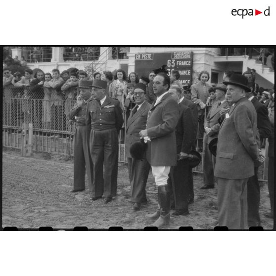 Autorités civiles, militaires et cavaliers regardant les courses du 11 concours hippique international d'Alger.