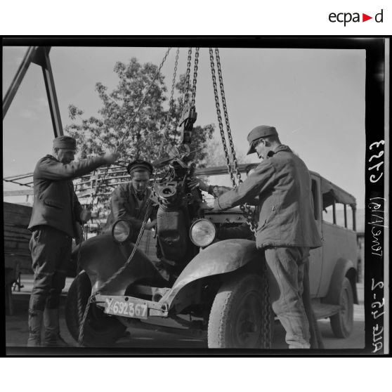 Des prisonniers de guerre allemands déposent un moteur dans l'atelier fixe des Issers.