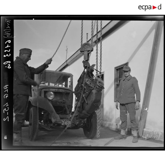 Des prisonniers de guerre allemands déposent un moteur, dans l'atelier fixe des Issers.