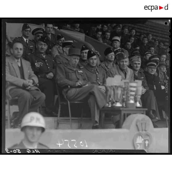 Tribune d'autorités militaires dans les gradins d'un stade d'Alger lors de la finale d'un championnat militaire.