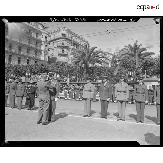 Remise de décorations par un général de division à un colonel lors de l'inauguration de la statue de Jeanne d'Arc à Alger.