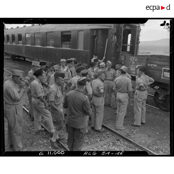 Officiers et éléments d'un régiment d'infanterie devant un wagon dans la région de Tebessa.