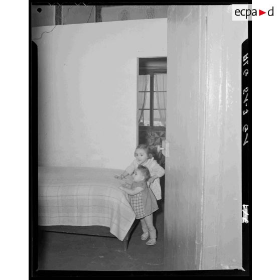 Enfants jouant dans la chambre d'un bidonville de la région d'Alger.