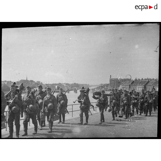 Rhe Feldy. [Des soldats allemands marchent le long d'un quai au bord d'une rivière]. [Description en cours]