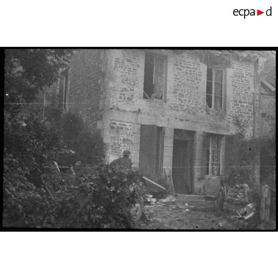 Normandie. [Un soldat devant une maison en partie détruite]. [Description en cours]