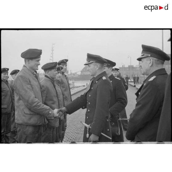 Sur un quai de Wilhelmshaven, les amiraux Doenitz et Carls passent en revue l'équipage de l'U-19 (ou U-3).