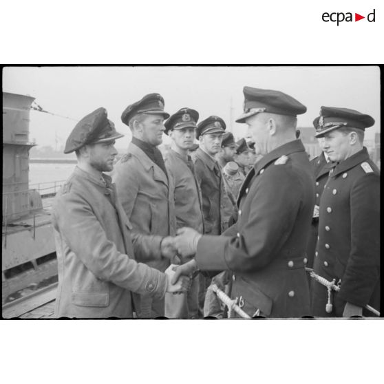 Les amiraux Doenitz et Carls passent en revue et félicitent l'équipage de l'U-37 sur un quai du port de Wilhelmshaven.