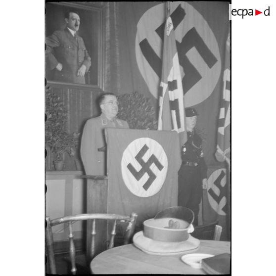 Discours d'un Gauleiter devant une peinture d'Adolf Hitler.