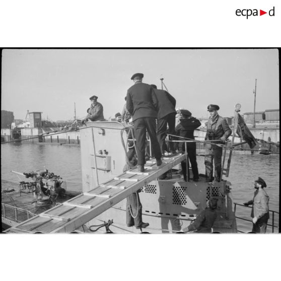 Une équipe de reporters de la Kriegsmarine monte à bord du sous-marin U-29 juste de retour de croisière à Wilhelmshaven.