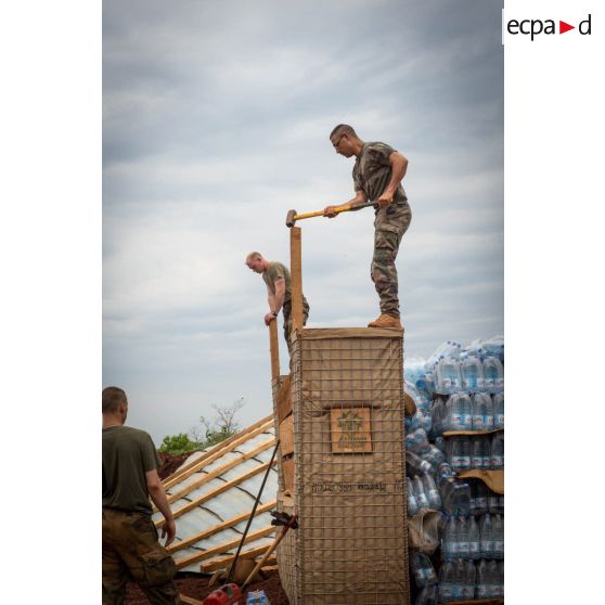 Soldats du 3e RG consolidant la charpente du pilier d'un bâtiment au moyen d'une masse, lors d'une intervention auprès du GTIA (groupement tactique interarmes) Turco, afin de procéder aux réparations des installations de l'aérodrome de Bambari détruites suite au passage d'une tempête.