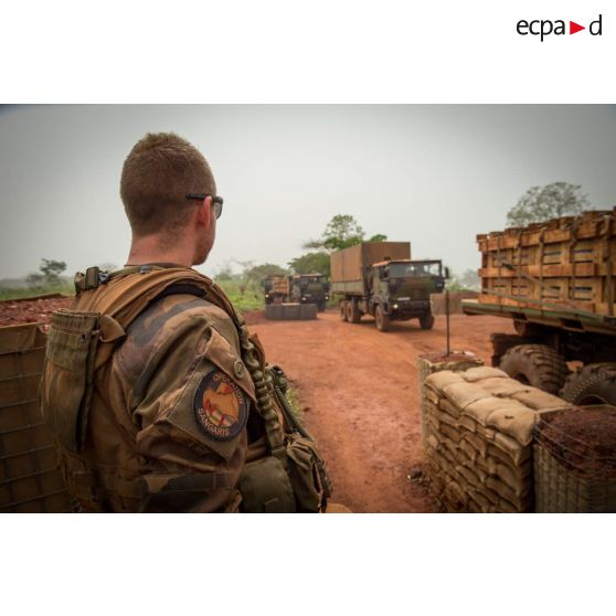 Sous le regard d'un soldat du GTIA (groupement tactique interarmes) Turco, un convoi logistique de camions TRM-10000 (toutes roues motrices) entre dans la POD (plateforme opérationnelle défense) de Bambari, lors d'un ravitaillement au profit des éléments sur place.