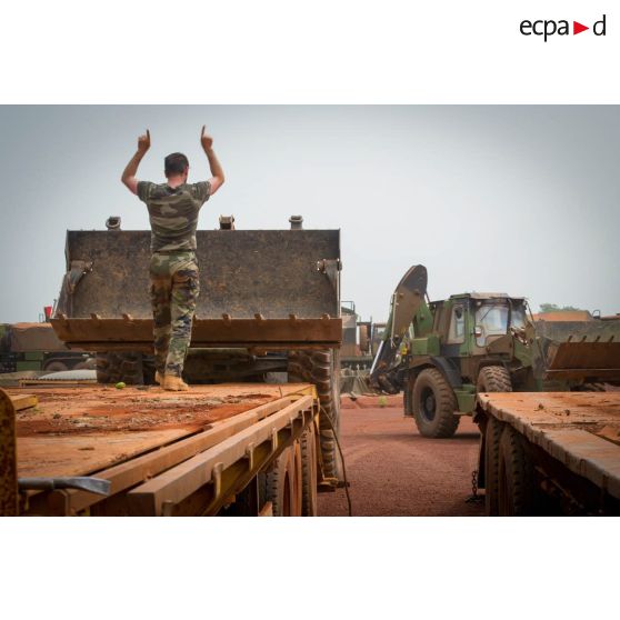 Déchargement d'un bulldozer depuis la plateforme d'un tracteur routier CBH-385 sur l'aérodrome de Bambari, par les soldats du GTIA (groupement tactique interarmes) Turco.