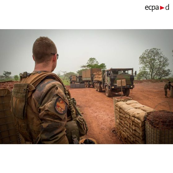 Sous le regard d'un soldat du GTIA (groupement tactique interarmes) Turco, un convoi logistique de camions TRM-10000 (toutes roues motrices) entre dans la POD (plateforme opérationnelle défense) de Bambari, lors d'un ravitaillement au profit des éléments sur place.