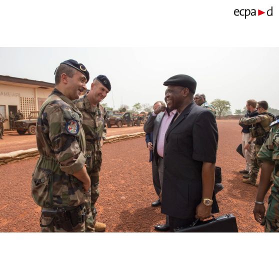 Le colonel Marc Espitalier, chef de corps du 1er RT et commandant le GTIA (groupement tactique interarmes) Turco, accueille monsieur Joseph Agbo, ministre des mines de la République centrafricaine, sur l'aérodrome de la POD (plateforme opérationnelle défense) de Bambari, en présence du général Éric Bellot des Minières, commandant la force Sangaris, lors de sa visite pour la cérémonie de réouverture du marché de la ville.