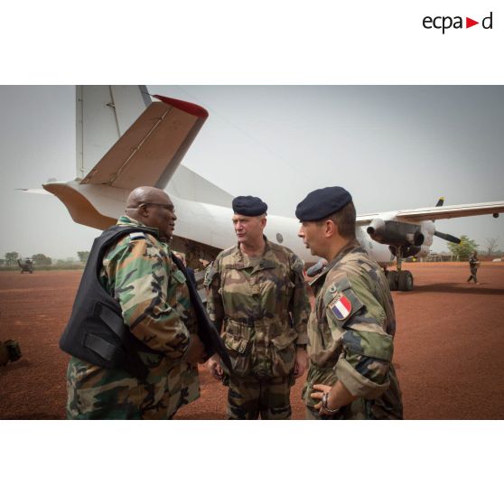 Le général Éric Bellot des Minières, commandant la force Sangaris, discute avec le lieutenant-colonel Guy-Bertrand Damango, directeur général de la gendarmerie nationale en présence du colonel Marc Espitalier, chef de corps du 1er RT et commandant le GTIA (groupement tactique interarmes) Turco, sur l'aérodrome de la POD (plateforme opérationnelle défense) de Bambari, lors de sa visite pour la cérémonie de réouverture du marché de la ville.