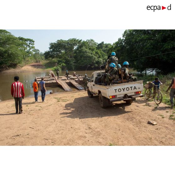 Eléments des forces armées de la MINUSCA (mission multidimensionnelle intégrée des Nations Unies pour la stabilisation en Centrafrique) à bord d'un pick-up Toyota, embarquant sur le bac de Gimbissi afin de franchir la rivière Baibou pour se rendre sur le site d'un charnier identifié dans la zone.