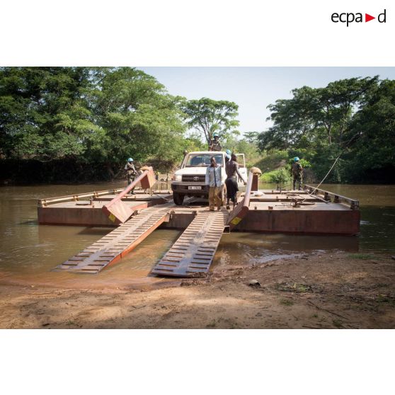 Eléments des forces armées de la MINUSCA (mission multidimensionnelle intégrée des Nations Unies pour la stabilisation en Centrafrique) à bord d'un pick-up Toyota, débarquant du bac de Gimbissi sur la rivière Baibou pour se rendre sur le site d'un charnier identifié dans la zone.