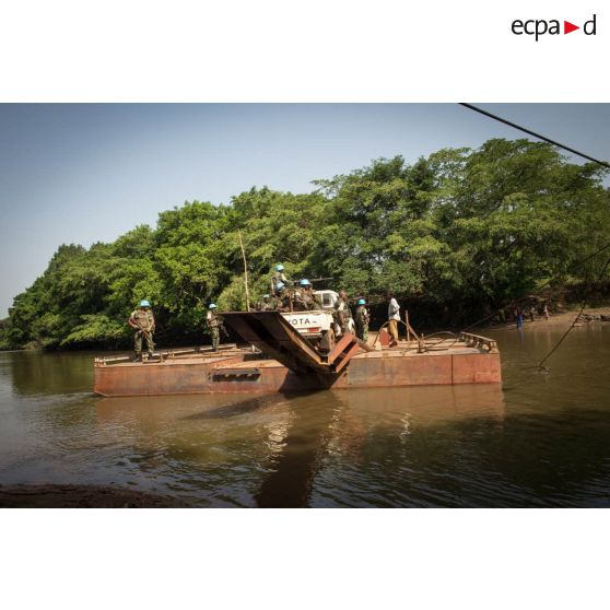 Eléments des forces armées de la MINUSCA (mission multidimensionnelle intégrée des Nations Unies pour la stabilisation en Centrafrique) à bord d'un pick-up Toyota, s'apprêtant à débarquer du bac de Gimbissi sur la rivière Baibou pour se rendre sur le site d'un charnier identifié dans la zone.