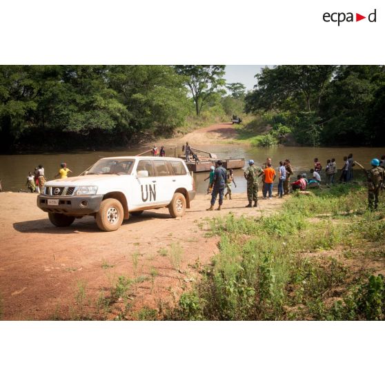 Une Nissan 4x4 siglée "UN" stationne sur les berges de la rivière Baibou, lors de la traversée de casques bleus de la MINUSCA (mission multidimensionnelle intégrée des Nations Unies pour la stabilisation en Centrafrique) par le bac de Gimbissi pour se rendre sur le site d'un charnier identifié dans la zone.