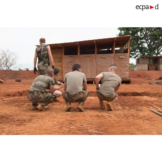 Soldats du groupe d'appui du Génie du GTIA (groupement tactique interarmes) Turco en briefing devant un module sanitaire afin de le transporter d'une fosse septique à une autre, dans le cadre du réaménagement des installations sanitaires de la POD (plateforme opérationnelle défense) de Bambari.