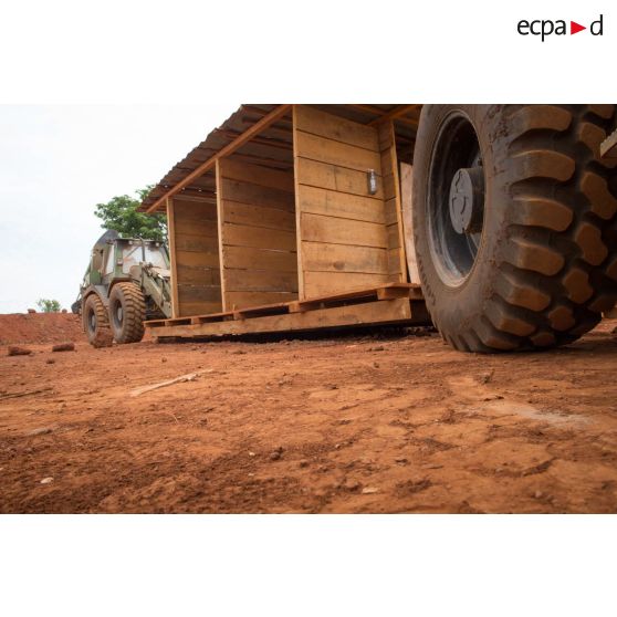 Tractopelles EGRAP (engin du génie rapide de protection) conduites par les soldats du groupe d'appui du Génie du GTIA (groupement tactique interarmes) Turco transportant un modèle sanitaire afin de le transporter d'une fosse septique à une autre, dans le cadre du réaménagement des installations sanitaires de la POD (plateforme opérationnelle défense) de Bambari.