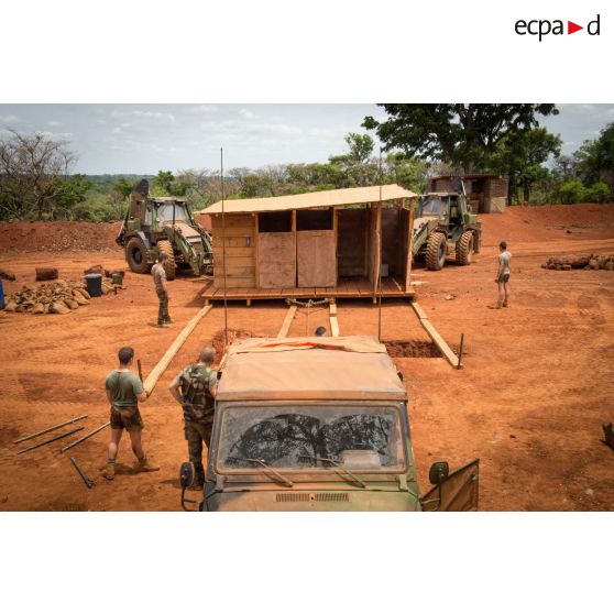 Soldats du groupe d'appui du Génie du GTIA (groupement tactique interarmes) Turco s'apprêtant à déplacer un module sanitaire afin de le transporter d'une fosse septique à une autre, dans le cadre du réaménagement des installations sanitaires de la POD (plateforme opérationnelle défense) de Bambari.