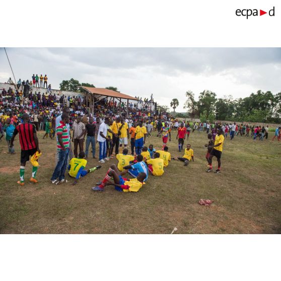 Joueurs de football se reposant en mi-temps sous le regard du public au cours d'une manifestation sportive pour la paix au stade de Bambari, lors de la journée internationale de la jeunesse.