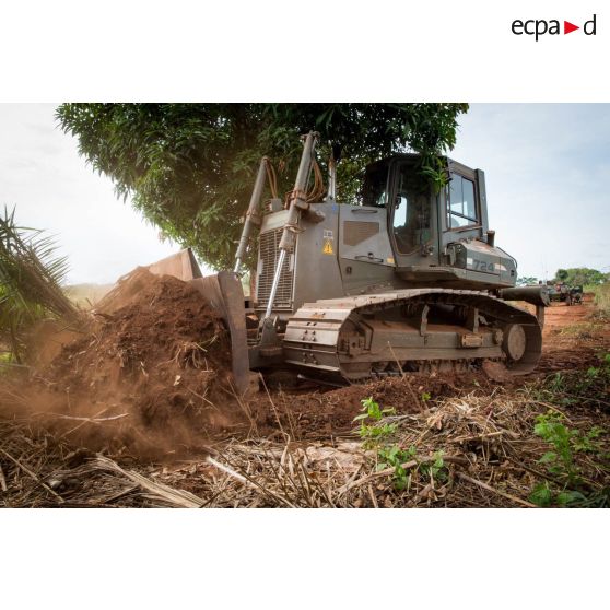 Un bulldozer Liebherr de type PR 724 LGP du 25e RGA déboise une zone en prévision de la réalisation d'un terrain de football au profit des habitants du village de Makangé.