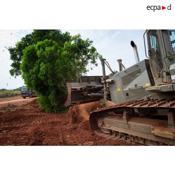 Un bulldozer Liebherr de type PR 724 LGP du 25e RGA déboise une zone en prévision de la réalisation d'un terrain de football au profit des habitants du village de Makangé.