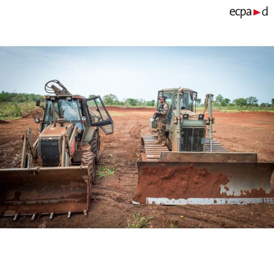 Une tractopelle EGRAP (engin du génie rapide de protection) et un bulldozer Liebherr de type PR 724 LGP du 25e RGA ratissent une zone en prévision de la réalisation d'un terrain de football au profit des habitants du village de Makangé.