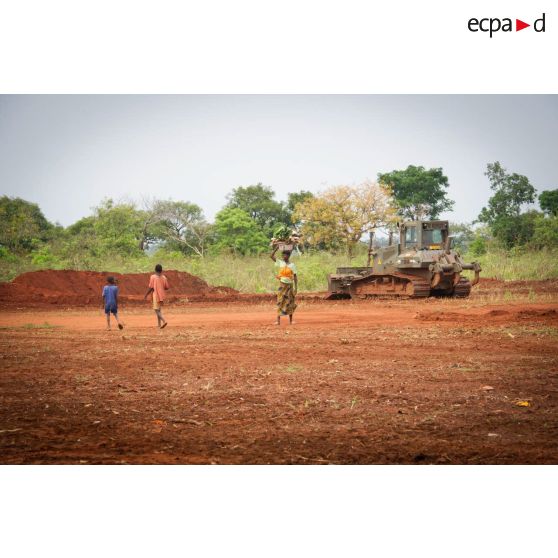 Habitants des environs de Makangé ramassant le petit bois d'une zone déboisée par un bulldozer Liebherr de type PR 724 LGP du 25e RGA en prévision de la réalisation d'un terrain de football.