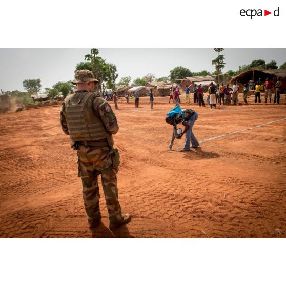 Sous les yeux d'un soldat du Génie de l'Air, des habitants du village de Makangé dressent les poteaux et les lignes d'un terrain de football récemment réalisé par le 25e RGA.