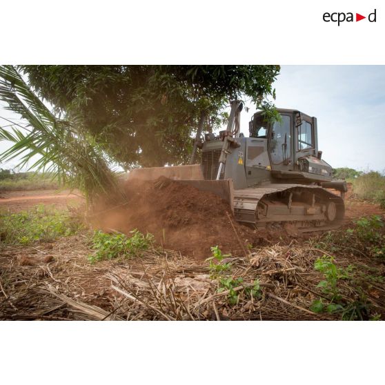 Un bulldozer Liebherr de type PR 724 LGP du 25e RGA déboise une zone en prévision de la réalisation d'un terrain de football au profit des habitants du village de Makangé.