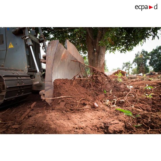 Lame d'un bulldozer Liebherr de type PR 724 LGP du 25e RGA déboisant une zone en prévision de la réalisation d'un terrain de football au profit des habitants du village de Makangé.