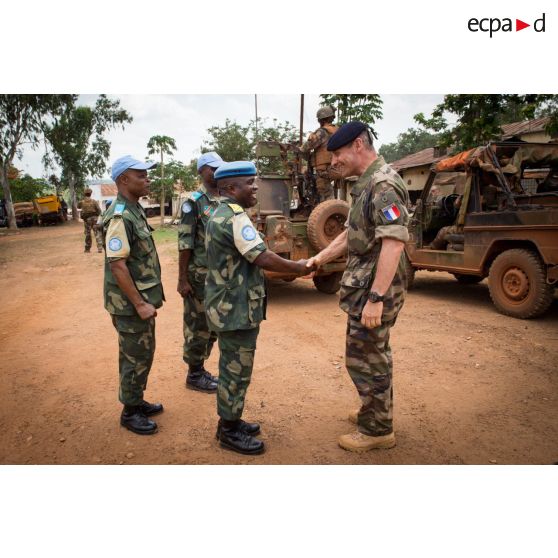 Le général de brigade Pierre Gillet, commandant la force Sangaris, salue un lieutenant-colonel de l'armée démocratique congolaise composante des casques bleus sur la place du siège régional de la MINUSCA (Mission multidimensionnelle intégrée des Nations Unies pour la stabilisation en Centrafrique), lors de sa visite aux soldats du GTIA (groupement tactique interarmes) Turco sur la POD (plateforme opérationnelle défense) de Bambari.